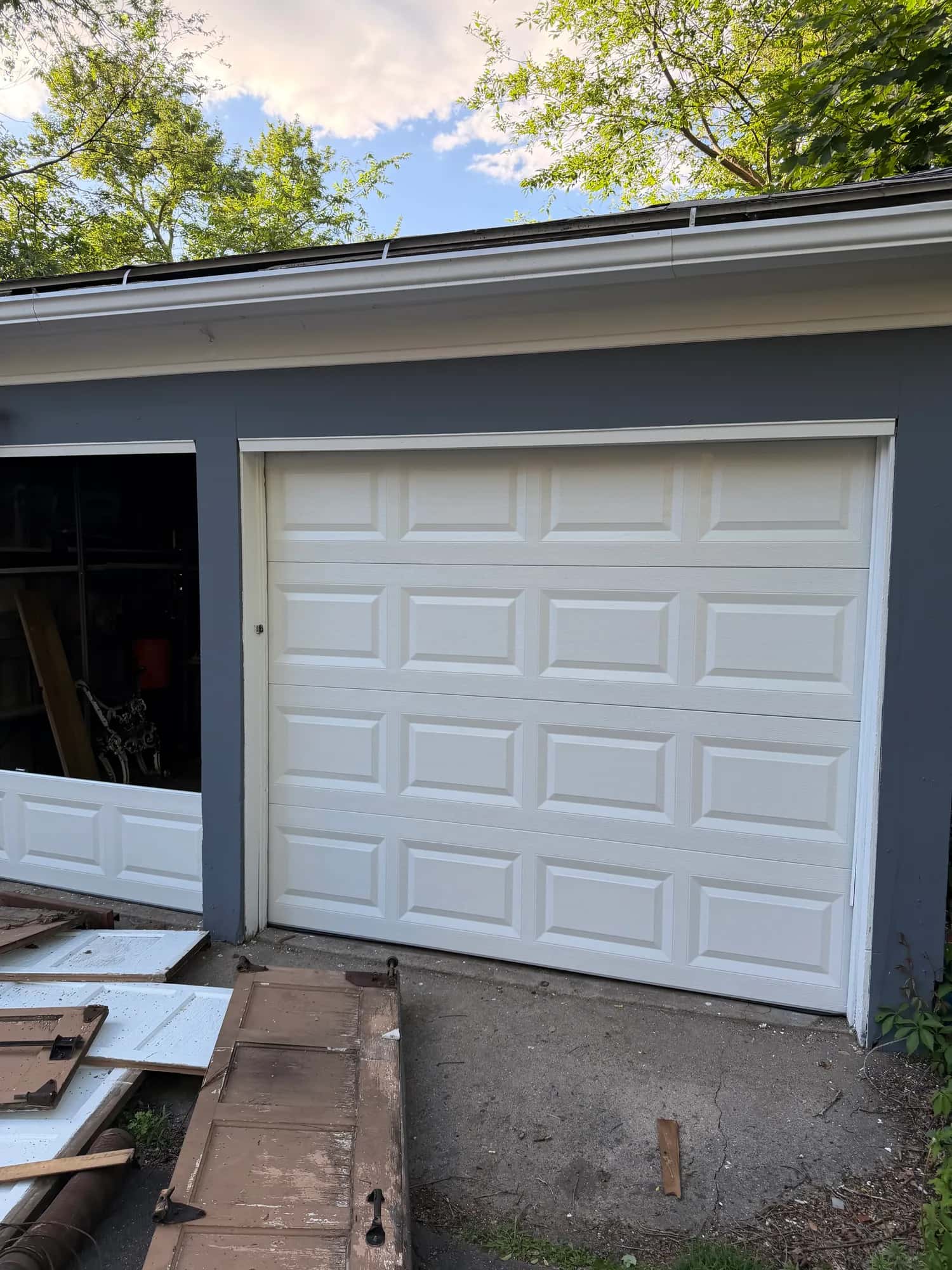Newly installed white double garage doors on a home